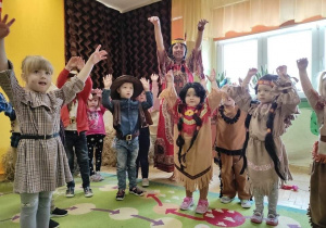 Dzieci przebrane w Kowboi i Indian tańczą taniec indiański.